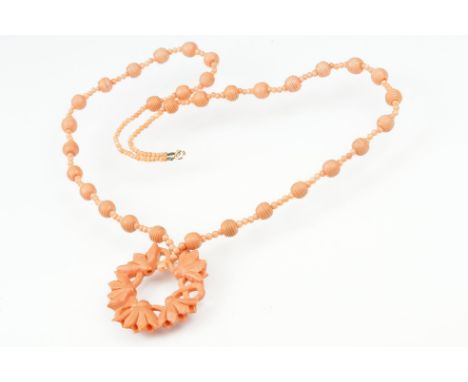 Early 20th century coral 9ct gold necklace, the principal carved coral disc depicting lotus flowers, diameter approx 4.5cm, c