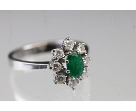 Emerald and diamond 18ct white gold cluster ring, oval mixed cut emerald, dimensions approx 6 x 4mm, claw set, eight round br