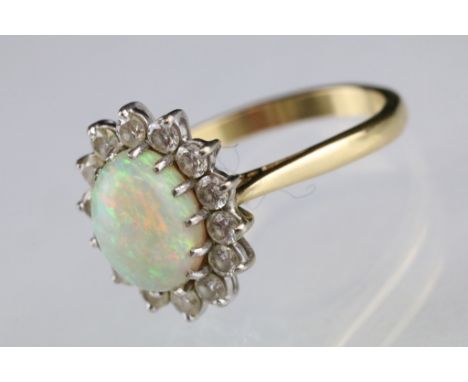 Opal and diamond 18ct yellow and white gold set cluster ring, the oval cabochon precious white opal displaying violet, indigo