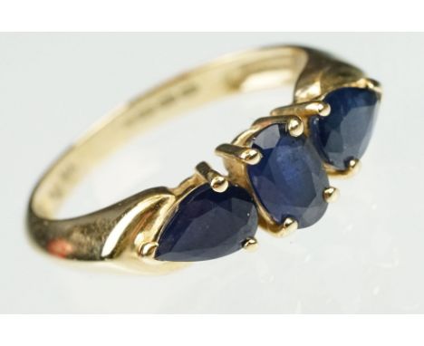 Sapphire 14ct yellow gold three stone ring, the central oval mixed cut blue sapphire measuring approx 6 x 4mm, claw settings,