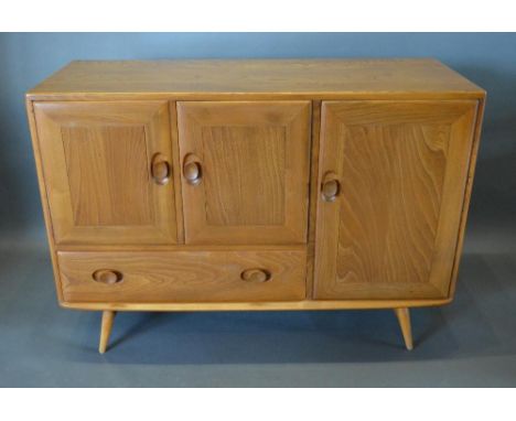 An Ercol Blonde Sideboard With Three Doors And A Drawer, raised upon turned legs with stretcher, together with an Ercol drop 