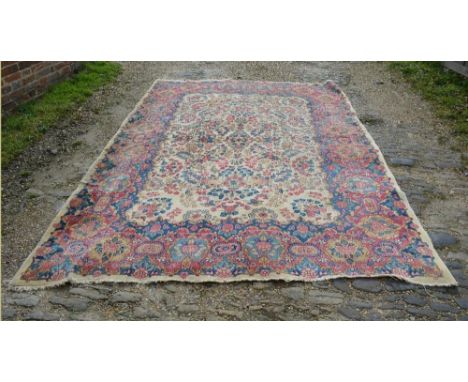 A North West Persian Woollen Carpet With An All Over Design Upon a cream, blue and red ground, 296cm by 218cm 