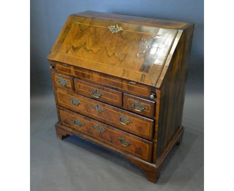 A George I Walnut Bureau The Fall Front Enclosing A Fitted Interior with well above three short and two long drawers with bra