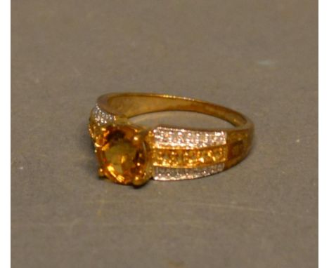 A 9ct Gold Citrine and Diamond Set Ring with a large citrine flanked by bands of diamonds and citrine 