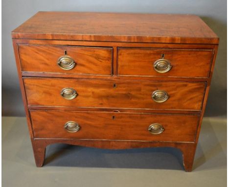 A 19th Century Mahogany Straight Front Chest Of Two Short and two long drawers with oval brass handles, raised upon bracket f