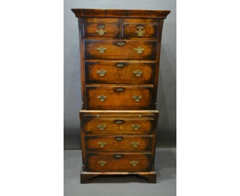 A Walnut Chest On Chest The Moulded Cornice Above two short, six long drawers and brushing slide with brass handles and escut