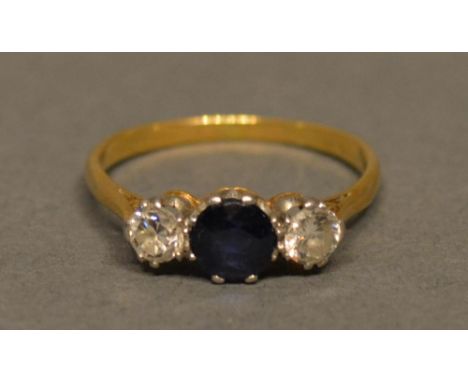 An 18ct. Gold, Sapphire And Diamond Three Stone Ring, with a central sapphire flanked by diamonds claw set 