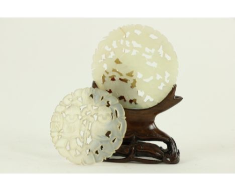 A carved and pierced light jade disc Pendant, with two children, 2" (5cms); together with another similar with three figures 