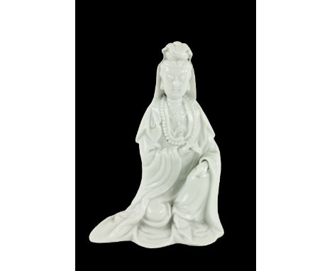 An early blanc-de-chine Chinese porcelain Figure,&nbsp;Quan Yin, she kneeling on one knee holding a scroll in her left hand a