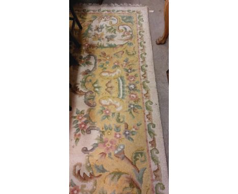 A large cream ground heavy woollen Carpet, with central floral panel and shaped similar decorated border, approx. 485cms x 37