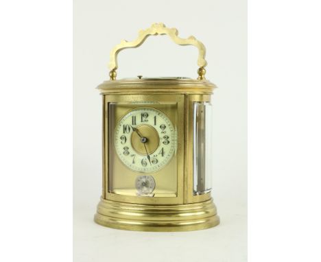 An attractive 19th Century oval cased brass Grande Sonnerie Carriage Clock,&nbsp;the enamel dial with Arabic numerals above c