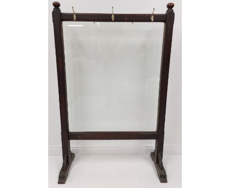A 19th Century mahogany cheval Screen, with two knop finials and a glazed panel now with various brass coat hooks, 143cms x 9