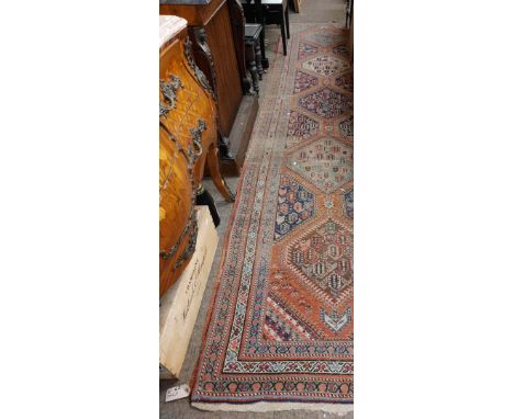 An attractive antique Middle Eastern&nbsp;woollen&nbsp;Carpet Runner,&nbsp; the central panel on claret ground with five meda