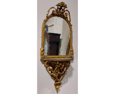 A very attractive 19th Century gilt Mirror Wall Bracket, with ornate floral crest above an arched plate and a bow fronted she