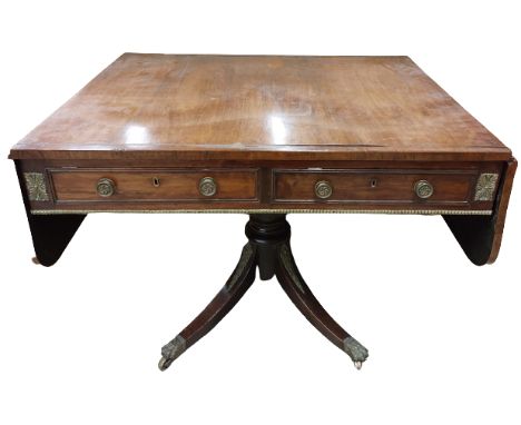 A late Regency period grained rosewood and brass inlaid Sofa Table, with brass mounts and two D shaped flaps flanking two moc