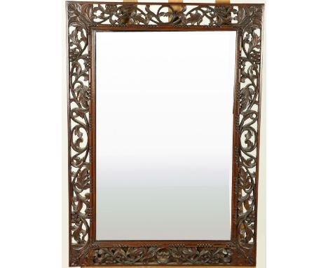 An ornate carved and pierced rosewood Mirror, with ornate scrolling vines, 28" x 20" (71cms x 51cms). (1) 