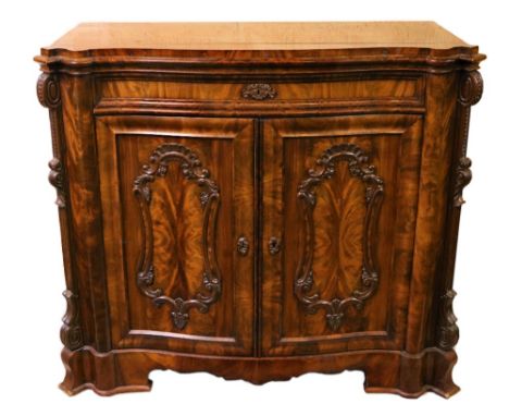 A fine quality Victorian figured mahogany serpentine shaped Drinks Cabinet, with moulded top over a frieze drawer, with two p