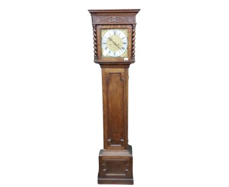 An oak Longcase Clock, in the 19th Century style, with moulded cornice above a carved frieze and a brass dial the silverised 