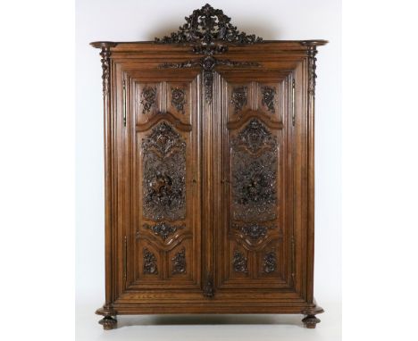 A fine 19th Century carved French Armoire, by V. Laruge (signed), with leaf carved cartouche crest on a moulded cornice above