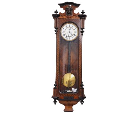 A 19th Century walnut Vienna Wall Clock, the capital with carved female face in relief over arched glazed panel, the circular