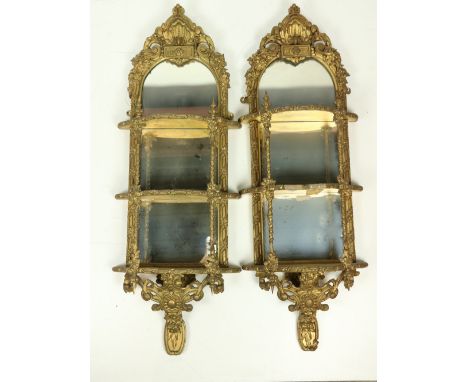 A very attractive pair of gilt Mirror Wall Brackets, each with a stylized shell crest above three shelves and cartouche apron