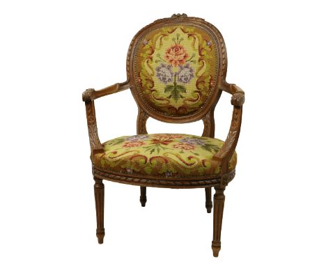 A carved and moulded French beech Fauteuil, with oval back covered in floral tapestry above an oval seat covered in matching 