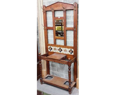 An attractive oak inlaid Hat, Stick and Umbrella Stand, the arched top over central bevelled mirror with five decorated Minto