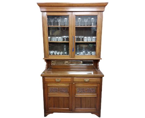 An Edwardian walnut Chiffonier or Cabinet, the moulded cornice above two glazed doors above a vacant compartment with mirror 