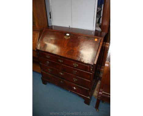 A Georgian Walnut Bureau having strip veneered top over the cross-banded strip veneered fall front, opening to reveal eight p