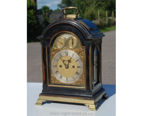 A George III brass bound ebonised Bracket Clock standing on a brass plinth and ogee feet, with a three pad top and brass carr