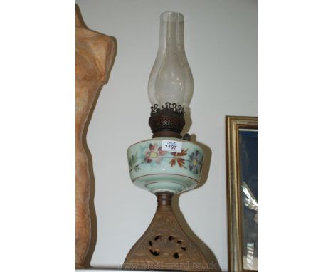 A Victorian Oil Lamp with cast metal base and green opaque, hand-painted glass reservoir.