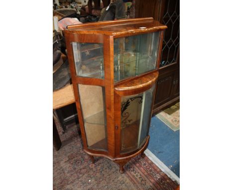 A 1920's Walnut china Display Cabinet, serpentine top with lipped back, over upper pair of sliding glass doors opening to rev