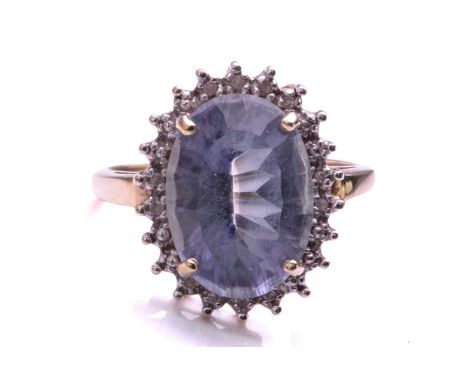 A Diamond and mystic quartz cluster ring; the oval cut purplish coated quartz within a border of beads and diamonds to a plai