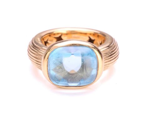 A topaz dress ring in 18ct yellow gold, comprising a rectangular buff-top topaz with a faceted pavilion, approximately measur