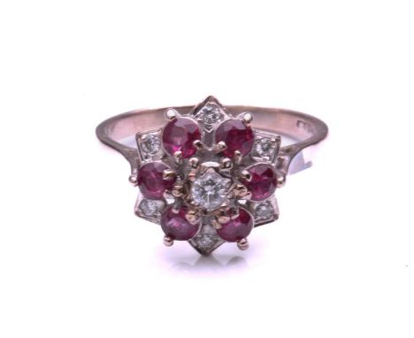 A ruby and diamond cluster ring, comprising a central round brilliant cut diamond above a border of five circular cut rubies 