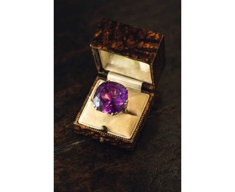 A large amethyst dress ring in 18ct yellow gold, featuring a cushion-shaped fancy-cut amethyst with intense purple body colou