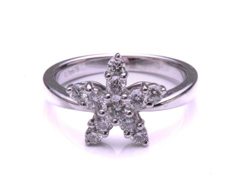 A French diamond cluster ring, composed of a star shaped flowerhead set with ten claw mounted brilliant cut diamonds beneath 