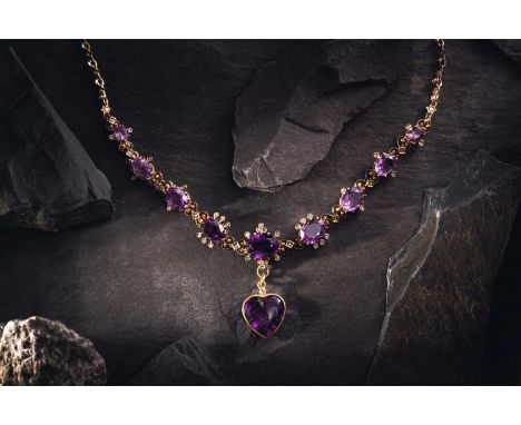 A Victorian amethyst and seed pearl necklace, nine graduated oval-cut amethyst in claw settings, encompassed by a seed pearl 