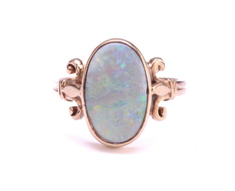 A precious opal dress ring in 9ct gold, featuring an elongated precious opal panel with greyish-blue ground, displaying spect