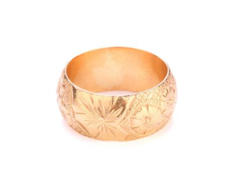 A 22ct yellow gold ring, the thick D-section band has been engraved with floral designs throughout, hallmarked '22ct', size P