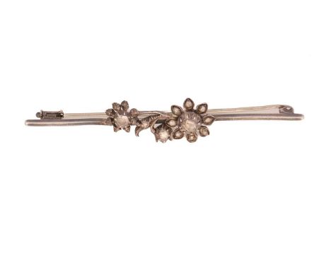 A floral bar brooch set with diamonds, the flower sprig motif in the centre has been mounted with rose-cut diamonds, to a bar