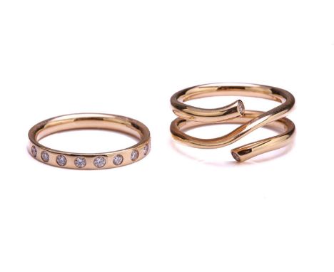 Georg Jensen - Two 18ct yellow gold and diamond rings from the 'MAGIC' collection; the first comprises a twist-around design,