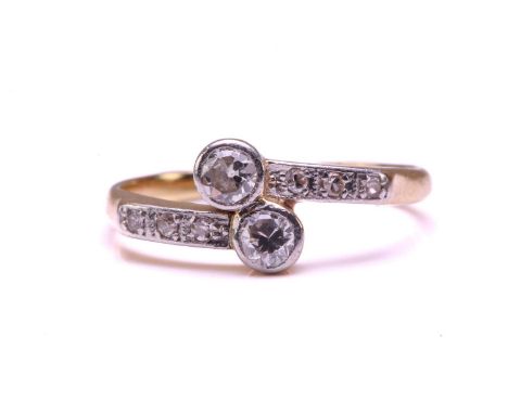 A diamond Toi et Moi bypass ring, scintillating with two larger old-European cut diamonds in collets, with diamond highlights