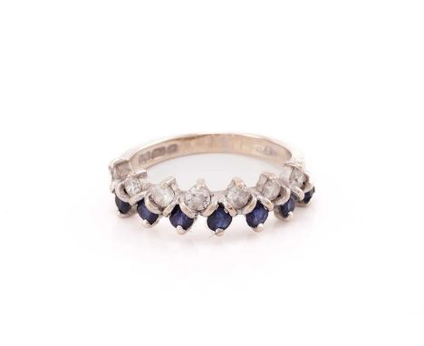 A two-row sapphire and diamond ring in 18ct white gold, comprises seven round sapphires and round diamonds, claw set to a tap