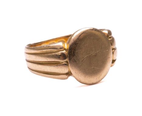 A Victorian signet ring in 18ct yellow gold, with a blank oval ring head to reeded shoulders and shank, Birmingham hallmarked