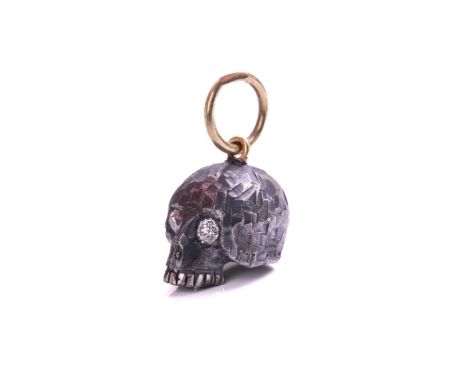 A skull charm pendant with diamonds, a sculpted hollow skull with eyes set with old-cut diamonds, with carved surface texture