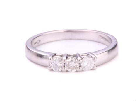 A three-stone diamond ring in platinum, with three circular-cut diamonds of 2.6 mm in claw settings, to tapering flat shank, 