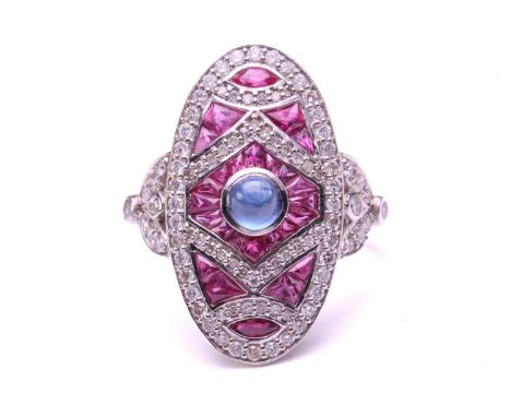 An art deco style oval panel ring set with a Sapphire and Rubies, the central cabochon Sapphire measures 4.0mm approximately 