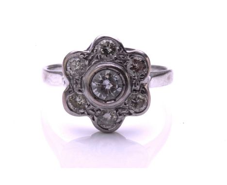 A diamond cluster ring; the seven stone round brilliant cut diamond cluster in flowerhead setting to plain, unmarked white me