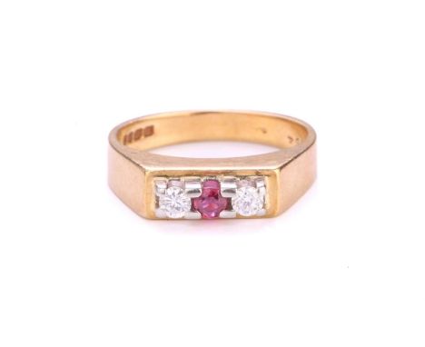 A three-stone diamond and ruby ring in 18ct gold, with a circular-cut ruby flanked by two diamonds, set on a flat panel, to a